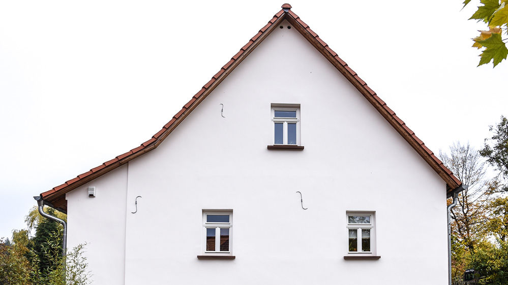 Frischer weißer Fassadenanstrich für Einfamalilienhaus durchgeführt von Zilch Malermeister in Frankfurt